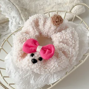 Detalle de coletero de oso de peluche con forro suave y lazo rosa para el cabello