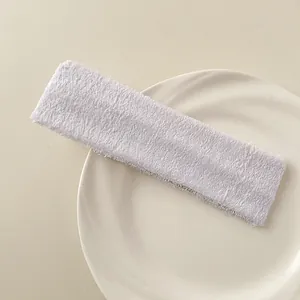 Close-up of white terry cloth sports headband with soft fabric texture and elastic design