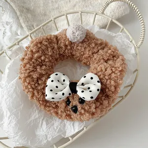 Detalle de coletero de osito de peluche marrón con lazo de lunares en una cesta