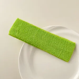 Detail of bright green terry cloth sports headband on a white ceramic plate