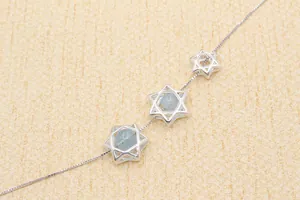 Macro detail of S925 sterling silver hexagram star pendant with light blue gemstones
