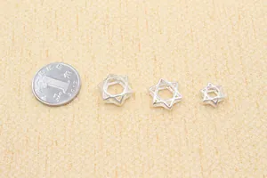Close-up of three hollow silver star charms in various sizes for DIY jewelry making