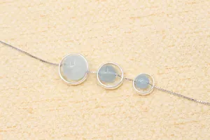 Detail of three-tier silver circular frame pendants with translucent light blue gemstones