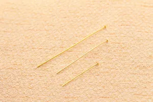 Macro dettagliata di chiodini a testa piatta dorati in tre dimensioni per fare gioielli