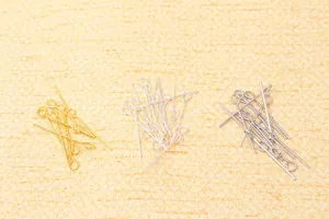 Detailed view of silver and gold plated metal eye pins for DIY jewelry making and beading