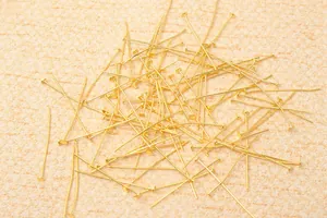 Dettaglio di chiodini a testa piatta dorati per la creazione di gioielli fai da te
