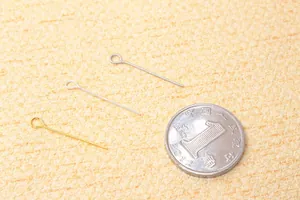 S925 silver eye pins in gold, silver, and antique bronze next to a coin for size reference