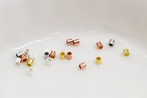 Macro shot of 1.5mm S925 silver crimp tube beads in gold, silver, and rose gold finishes