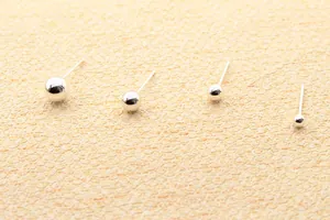 Detailopname van vier verschillende maten gepolijste S925 sterling zilveren bolletjes oorbellen