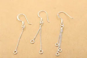 Detailed view of silver box chain earring hooks with single, double, and triple strands