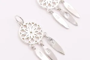 Macro shot of S925 sterling silver dreamcatcher pendant with three delicate hanging feathers