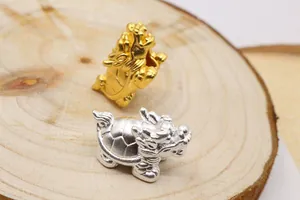 Makroaufnahme von 3D-Drachenschildkröten-Perlen in Gold und Silber für DIY-Schmuck