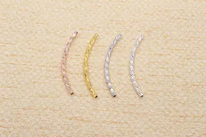 Close-up of S925 sterling silver curved tubes with spiral texture in gold and rose gold