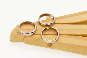 Detail shot of S925 sterling silver hollow rings with screw motif on wooden stand