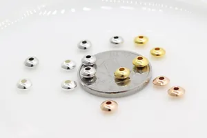 Macro detail of metallic saucer beads in silver, gold, and rose gold for DIY jewelry