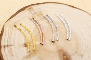 Detailed macro view of S925 sterling silver curved tubes for DIY jewelry in gold and rose gold