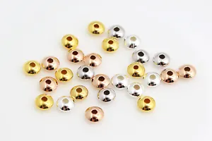 Detailed macro view of polished gold, silver, and rose gold rondelle spacer beads