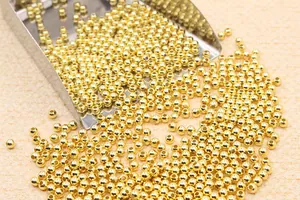 Macro shot of small polished gold metal spacer beads for DIY jewelry making and craft projects