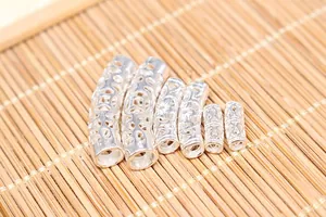 Detailed macro view of S925 sterling silver hollow curved tubes with floral relief patterns