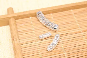Detailed view of hollow patterned S925 sterling silver curved tube beads for DIY jewelry