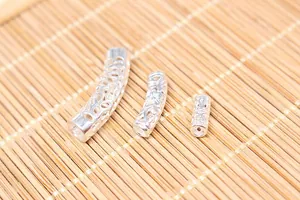 Detailed view of three sizes of hollow patterned S925 silver curved tubes for DIY jewelry