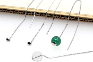 Dettaglio macro di orecchini a catena S925 in argento con perline verdi e trasparenti
