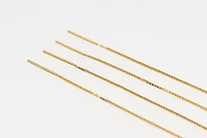 Dettaglio di quattro fili per orecchini a catena veneziana dorata con aghi per gioielli