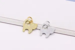 Dettaglio di ciondoli a gatto in argento S925 con finitura martellata oro e argento.