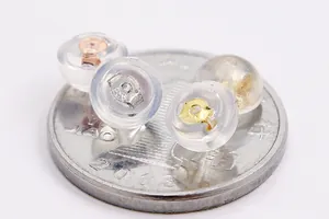Vista macro de cierres de pendientes de plata S925 y silicona sobre moneda para escala