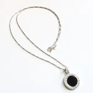 Detalle de la cadena box de plata S925 con un colgante redondo de piedra de ónice negro
