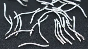 Macro shot of 1.5mm S925 sterling silver curved noodle tube beads for DIY jewelry making