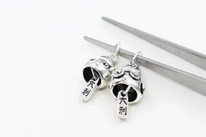 Detailed macro view of vintage S925 silver lucky cat charms with Da Li engraving