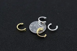 Macro view of C-shaped S925 silver earring parts in gold and silver finish with coin