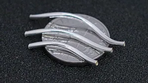 Macro view of 1.5mm S925 sterling silver S-curved tubes for DIY jewelry on a coin