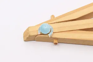 Macro detail of a light blue gemstone bead set in a S925 sterling silver semi-circle frame