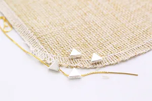 Close-up of S925 sterling silver triangle pendants with S925 engraving and gold chain detail