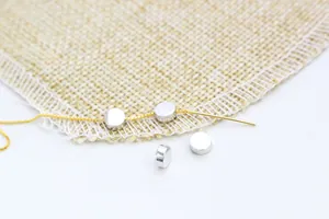 Close-up of S925 sterling silver round spacer beads on a gold needle chain for DIY crafts