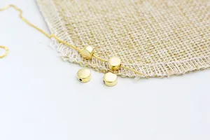 Close-up of golden flat round spacer beads with polished surface for DIY jewelry making
