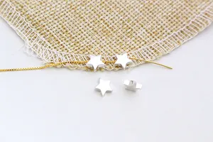 Macro shot of S925 sterling silver star-shaped beads on a delicate gold chain for DIY jewelry