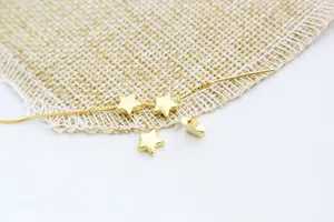 Macro detail of matte gold star spacer beads with side holes for DIY jewelry making