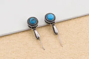 Macro shot of vintage S925 sterling silver earrings with round turquoise stones and rope edge