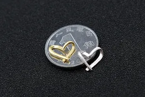 Dettaglio macro di ciondoli a cuore in argento S925 oro e argento con scala dimensionale
