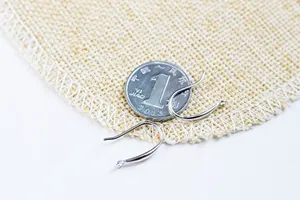 Gros plan de crochets d'oreilles en argent 925 avec poinçon S925 près d'une pièce