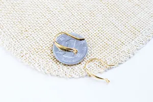 Gros plan de crochets d'oreilles en argent doré avec boucle et pièce de monnaie