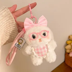 Close-up of plush rabbit keychain with pink bow and glasses accessory for bags