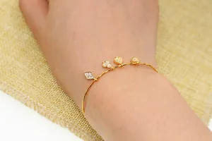 Gedetailleerde weergave van vergulde armband met zirkonia bedeltjes in de vorm van kaarten