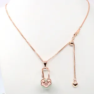 Close-up of S925 sterling silver Ruyi lock pendant with green gemstone on a rose gold chain