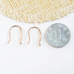 Crochets d'oreilles DIY en argent 925 or rose avec anneaux à côté d'une pièce