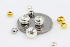Vue macro détaillée de perles à écraser en argent S925 dorées et argentées avec pièce