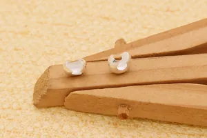 Vue rapprochée de cache-nœuds en argent S925 sur bois pour la création de bijoux DIY